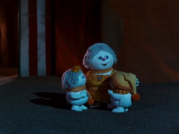 Movie still from “Rudolph and Frosty's Christmas in July” (1979), directed by Jules Bass – A couple of toy figures are standing next to each other; Medium shot, Low angle