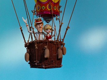 Movie still from “Rudolph and Frosty's Christmas in July” (1979), directed by Jules Bass – A couple of people are in a hot air balloon; Wide shot, Low angle