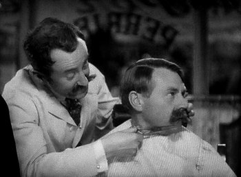 Movie still from “Ruggles of Red Gap” (1935), directed by Leo McCarey – An old photo of a man getting his hair cut; Close Up shot, Over the shoulder angle