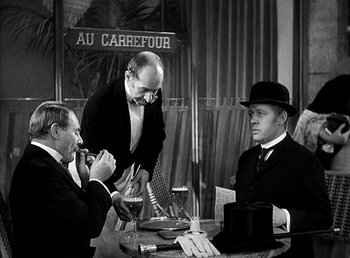 Movie still from “Ruggles of Red Gap” (1935), directed by Leo McCarey – A group of men sitting at a table with wine glasses; Medium shot, Over the shoulder angle