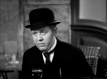 Movie still from “Ruggles of Red Gap” (1935), directed by Leo McCarey – A man wearing a hat and a suit and holding a glass of beer; Close Up shot, High angle