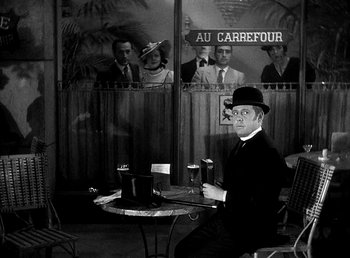 Movie still from “Ruggles of Red Gap” (1935), directed by Leo McCarey – A black and white photo of a man sitting at a table; Wide shot, High angle