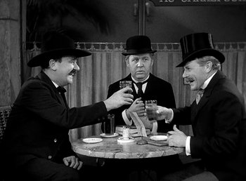 Movie still from “Ruggles of Red Gap” (1935), directed by Leo McCarey – A group of men sitting at a table with drinks; Medium shot, Low angle