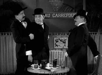 Movie still from “Ruggles of Red Gap” (1935), directed by Leo McCarey – A group of men standing next to each other in suits; Medium shot, Over the shoulder angle