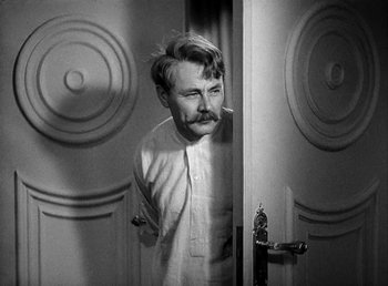 Movie still from “Ruggles of Red Gap” (1935), directed by Leo McCarey – A black and white photo of a man standing in front of a door; Close Up shot, Over the shoulder angle