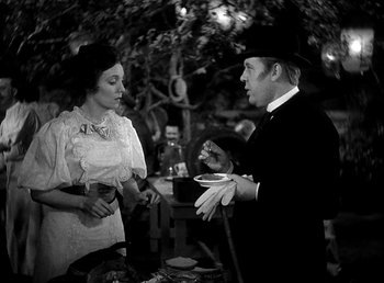 Movie still from “Ruggles of Red Gap” (1935), directed by Leo McCarey – A man and a woman standing next to each other; Medium shot, High angle