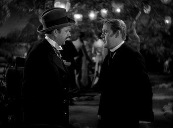 Movie still from “Ruggles of Red Gap” (1935), directed by Leo McCarey – Two men in suits talking to each other outside; Medium shot, Over the shoulder angle