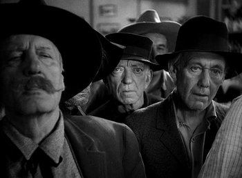 Movie still from “Ruggles of Red Gap” (1935), directed by Leo McCarey – Black and white photograph of a group of men wearing hats; Medium shot, Low angle
