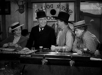 Movie still from “Ruggles of Red Gap” (1935), directed by Leo McCarey – A group of people sitting at a bar with hats on; Medium shot, Low angle