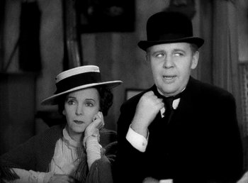 Movie still from “Ruggles of Red Gap” (1935), directed by Leo McCarey – An older man and a woman in hats and suits; Medium shot, Low angle