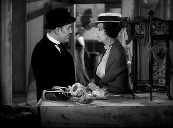 Movie still from “Ruggles of Red Gap” (1935), directed by Leo McCarey – An old photo of a man and a woman talking to each other; Medium shot, High angle