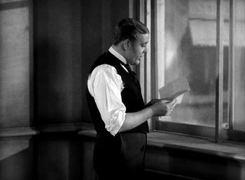 Movie still from “Ruggles of Red Gap” (1935), directed by Leo McCarey – A man standing in front of a window holding a piece of paper; Medium shot, Low angle
