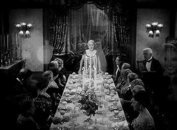 Movie still from “Ruggles of Red Gap” (1935), directed by Leo McCarey – A group of people sitting around a long dinner table; Wide shot, High angle