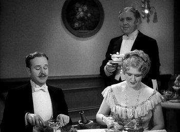 Movie still from “Ruggles of Red Gap” (1935), directed by Leo McCarey – A man and a woman sitting at a dinner table; Medium shot, High angle