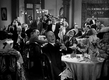 Movie still from “Ruggles of Red Gap” (1935), directed by Leo McCarey – A group of people sitting at a table with drinks; Wide shot, High angle