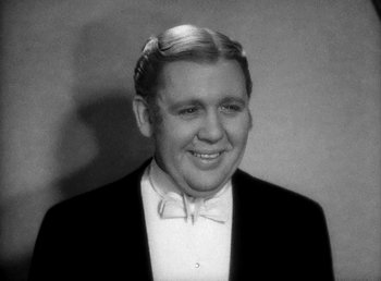 Movie still from “Ruggles of Red Gap” (1935), directed by Leo McCarey – An old photo of a man in a tuxedo smiling for the camera; Close Up shot, Low angle