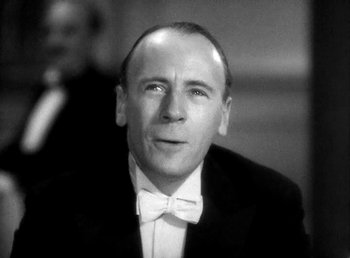 Movie still from “Ruggles of Red Gap” (1935), directed by Leo McCarey – A man wearing a suit and bow tie; Close Up shot, Low angle