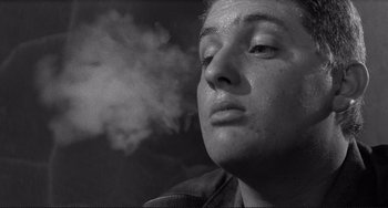 Movie still from “Rumble Fish” (1983), directed by Francis Ford Coppola – A person with a cigarette in their mouth; Close Up shot, Low angle