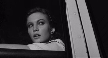 Movie still from “Rumble Fish” (1983), directed by Francis Ford Coppola – A black - and - white photo of a woman looking out of a window; Close Up shot, Low angle
