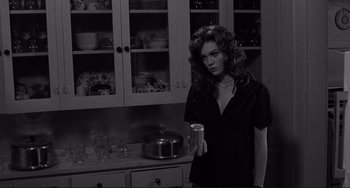 Movie still from “Rumble Fish” (1983), directed by Francis Ford Coppola – A black and white photo of a woman holding a can; Medium shot, Over the shoulder angle