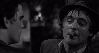 Movie still from “Rumble Fish” (1983), directed by Francis Ford Coppola – A black and white photo of a man smoking a cigarette; Close Up shot, Over the shoulder angle