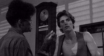 Movie still from “Rumble Fish” (1983), directed by Francis Ford Coppola – Two people talking to each other in front of a grandfather clock; Close Up shot, Over the shoulder angle