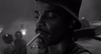 Movie still from “Rumble Fish” (1983), directed by Francis Ford Coppola – A black and white photo of a man smoking a cigarette; Close Up shot, Low angle