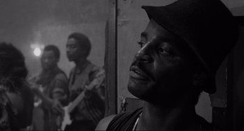 Movie still from “Rumble Fish” (1983), directed by Francis Ford Coppola – A black and white photo of a man with a hat on; Close Up shot, Low angle