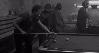 Movie still from “Rumble Fish” (1983), directed by Francis Ford Coppola – A group of men playing a game of billiards; Medium shot, High angle