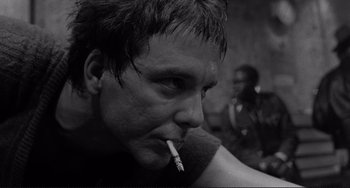 Movie still from “Rumble Fish” (1983), directed by Francis Ford Coppola – A person smoking a cigarette; Close Up shot, Low angle