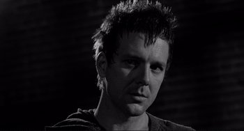 Movie still from “Rumble Fish” (1983), directed by Francis Ford Coppola – Black and white photograph of a man with spiky hair; Close Up shot, Low angle