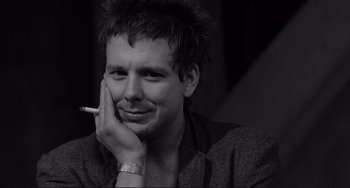 Movie still from “Rumble Fish” (1983), directed by Francis Ford Coppola – A black and white photo of a man smoking a cigarette; Close Up shot, Low angle