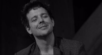 Movie still from “Rumble Fish” (1983), directed by Francis Ford Coppola – A black and white photo of a man smiling; Close Up shot, Low angle
