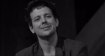 Movie still from “Rumble Fish” (1983), directed by Francis Ford Coppola – Black and white photograph of a man smiling for the camera; Close Up shot, Low angle