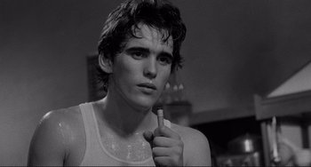 Movie still from “Rumble Fish” (1983), directed by Francis Ford Coppola – Black and white photograph of a young man holding a toothbrush; Close Up shot, Low angle