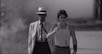 Movie still from “Rumble Fish” (1983), directed by Francis Ford Coppola – A man and a man in a suit and tie; Medium shot, Over the shoulder angle