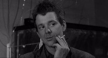 Movie still from “Rumble Fish” (1983), directed by Francis Ford Coppola – A black and white photo of a man smoking a cigarette; Close Up shot, Low angle