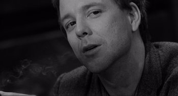 Movie still from “Rumble Fish” (1983), directed by Francis Ford Coppola – Black and white photograph of a man smoking a cigarette; Close Up shot, Low angle