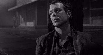 Movie still from “Rumble Fish” (1983), directed by Francis Ford Coppola – Black and white photograph of a man in a suit; Close Up shot, Low angle