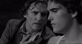 Movie still from “Rumble Fish” (1983), directed by Francis Ford Coppola – A man and a boy looking at one another; Close Up shot, Over the shoulder angle
