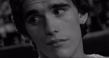Movie still from “Rumble Fish” (1983), directed by Francis Ford Coppola – A young man's face in black - and - white; Close Up shot, High angle