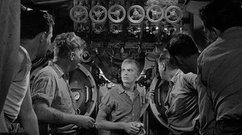 Movie still from “Run Silent Run Deep” (1958), directed by Robert Wise – A group of men standing next to each other in a room; Medium shot, High angle