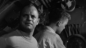 Movie still from “Run Silent Run Deep” (1958), directed by Robert Wise – A black - and - white photo of a man with a beard; Close Up shot, Low angle