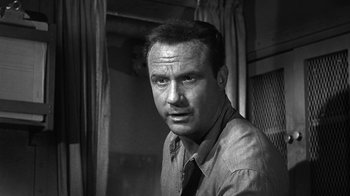 Movie still from “Run Silent Run Deep” (1958), directed by Robert Wise – Black and white photograph of a man in a shirt and tie; Close Up shot, Low angle
