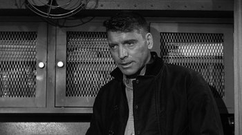 Movie still from “Run Silent Run Deep” (1958), directed by Robert Wise – Black and white photograph of a man wearing a jacket; Close Up shot, Over the shoulder angle