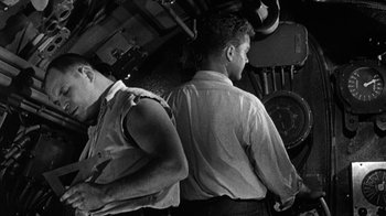 Movie still from “Run Silent Run Deep” (1958), directed by Robert Wise – Two men are standing next to each other; Medium shot, Low angle