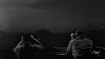 Movie still from “Run Silent Run Deep” (1958), directed by Robert Wise – Two men sitting on a boat in the water; Wide shot, Over the shoulder angle