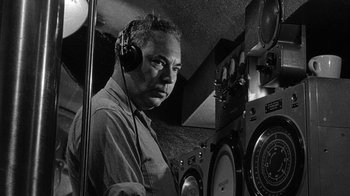 Movie still from “Run Silent Run Deep” (1958), directed by Robert Wise – A black and white photo of a man wearing headphones; Close Up shot, Low angle