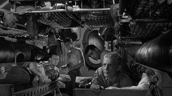 Movie still from “Run Silent Run Deep” (1958), directed by Robert Wise – A black and white photo of a group of men in a room; Medium shot, High angle