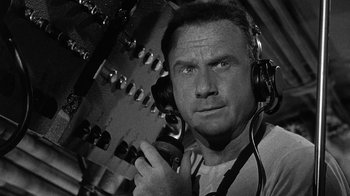 Movie still from “Run Silent Run Deep” (1958), directed by Robert Wise – A black and white photo of a man with headphones; Close Up shot, Low angle